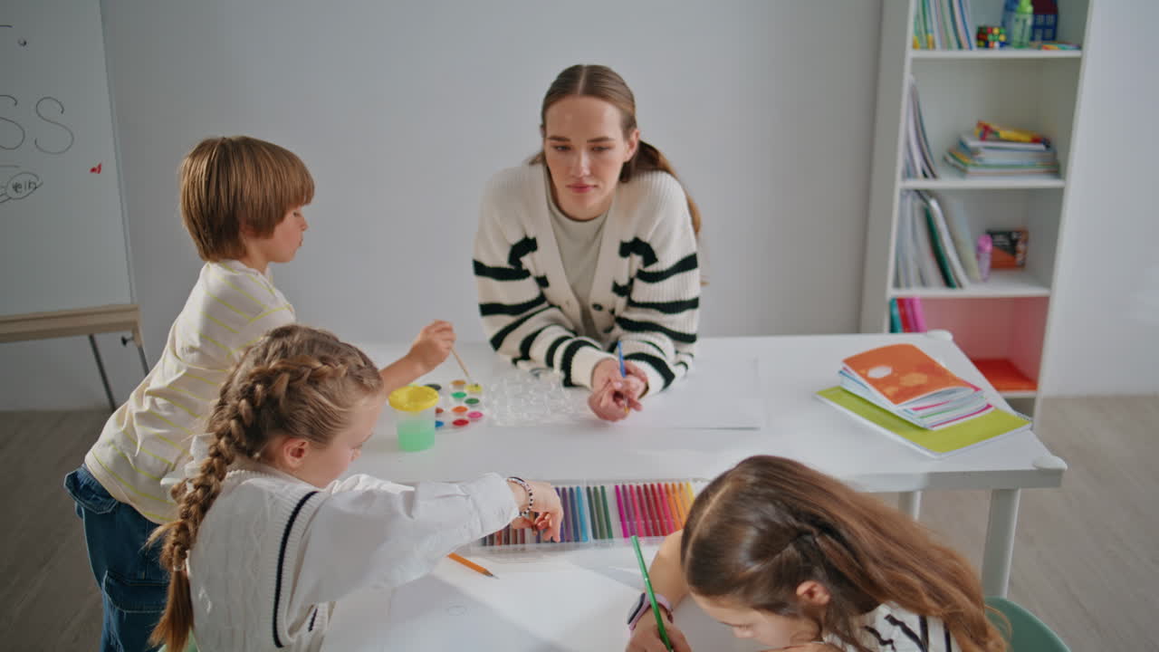 Inspirativní kamarádky tvoří obrázky ve škole, detailní záběr. Dvě dívky kreslí tužkami