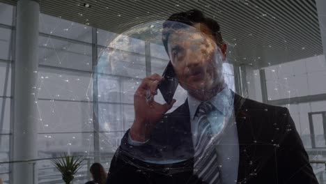 Animation-of-connections-and-globe-over-biracial-businessman-using-smartphone