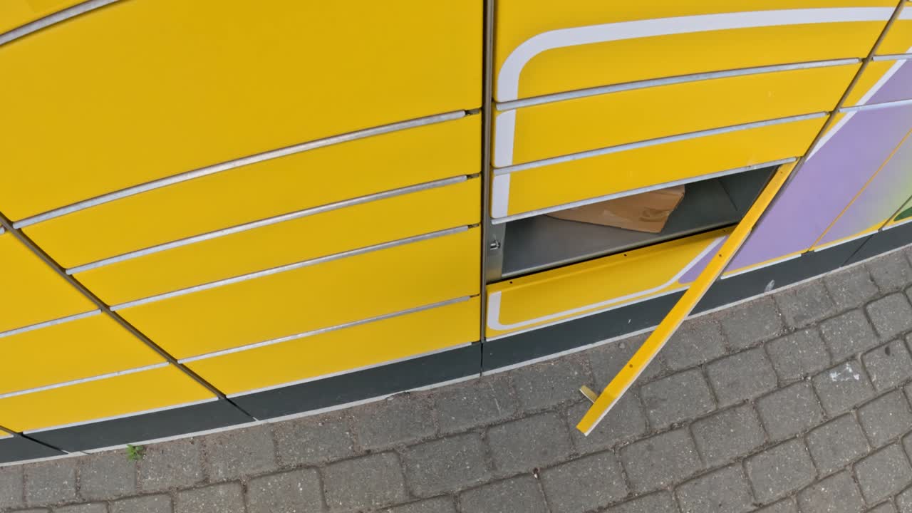 Opening yellow parcel machine door, POV