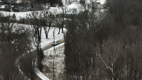 Vehicle-Driving-On-Road-Through-Snowy-Landscape-In-Winter-In-Arkansas,-USA