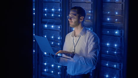 ingeniero de servidor masculino en un centro de datos. ingeniero de it inspeccionando un gabinete de servidor seguro usando tecnología moderna laptop coworking en un centro de datos.