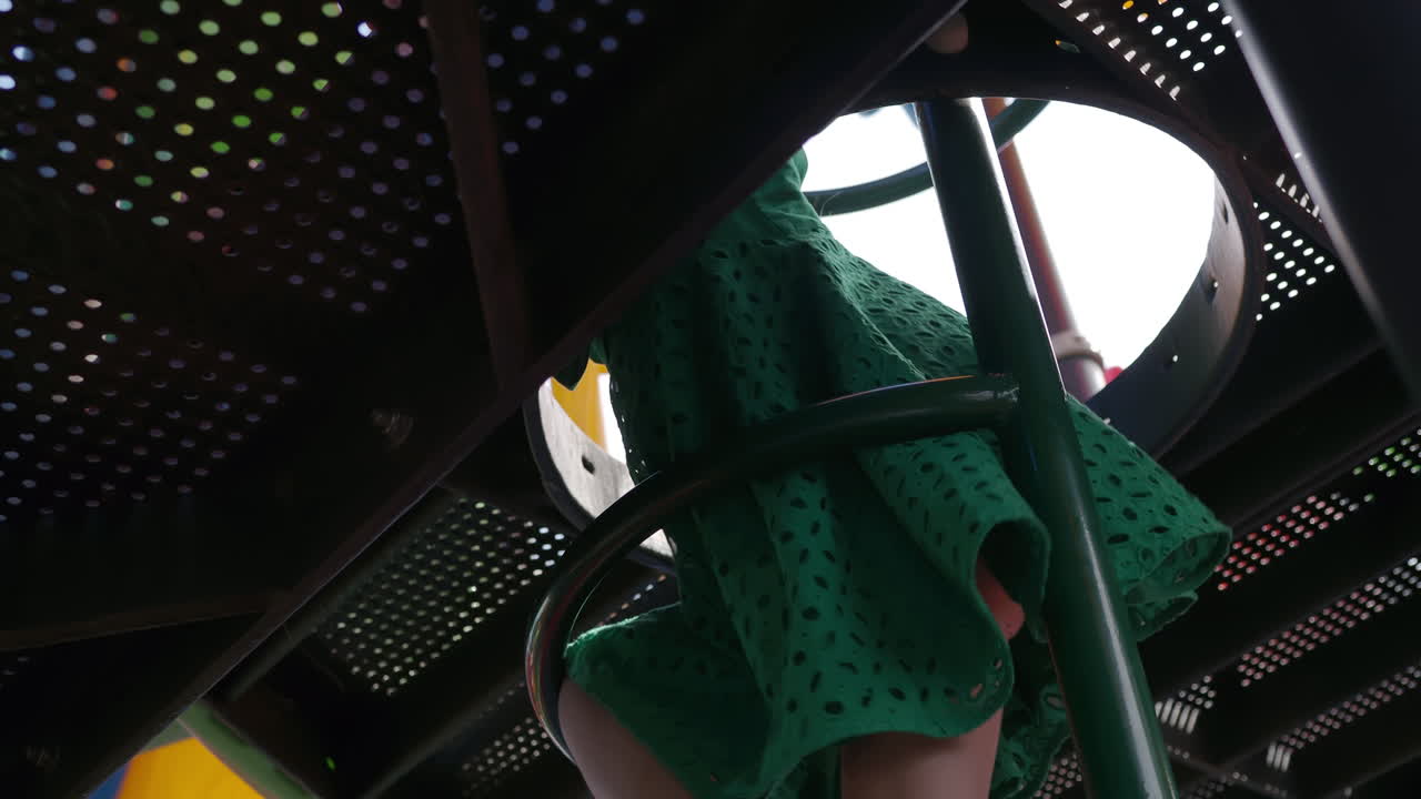 niña joven escalando estructura de juego al aire libre