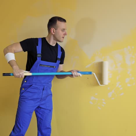 man painting wall at home. portrait view of painter hands painting the wall