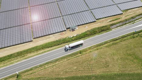 truck driving on the highway through solar farm