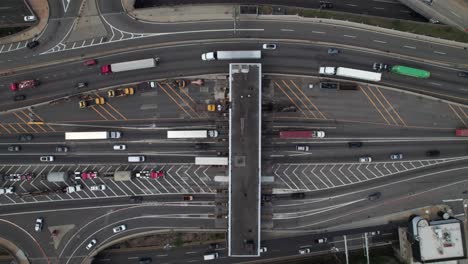 trucks and cars going through ez pass toll plaza in new york, 4k overhead aerial