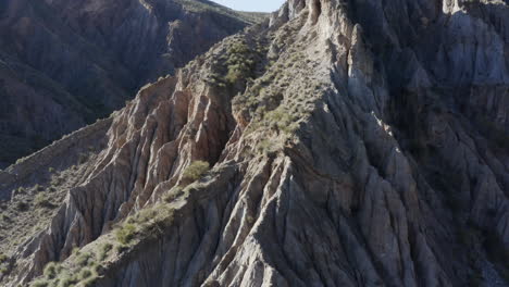 breathtaking rocky outcrop in a mountain range, aerial panning right