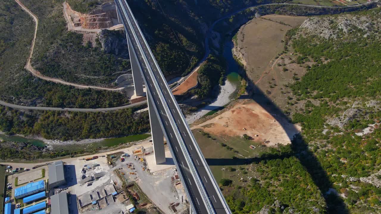 fotografía aérea del puente moracica completamente terminado en montenegro. el gran escudo de armas rojo de montenegro se ve en uno de los pilares del puente