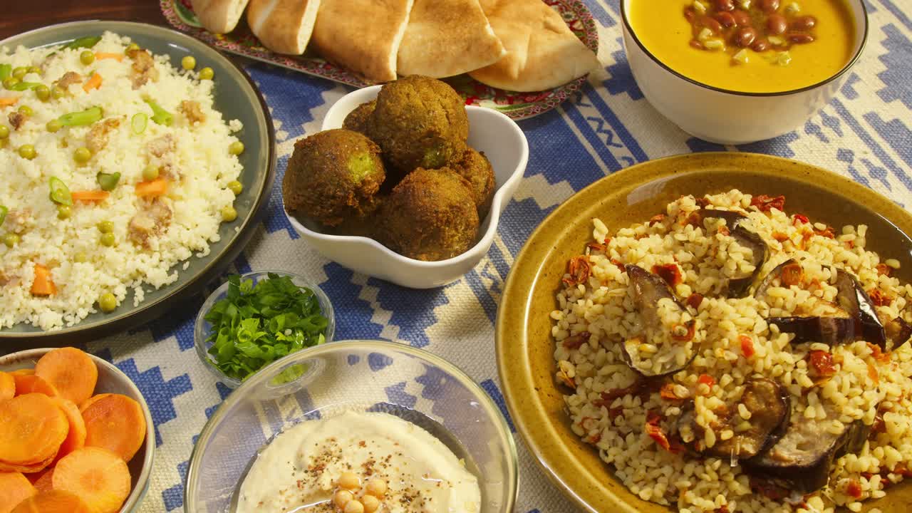 cocina árabe. bulgur con berenjena, falafel, sopa de frijoles en la mesa, cuscús con pollo. cultura tradicional de oriente medio. moutabal y ensalada de verduras en cuencos, pita. arroz delicioso con carne