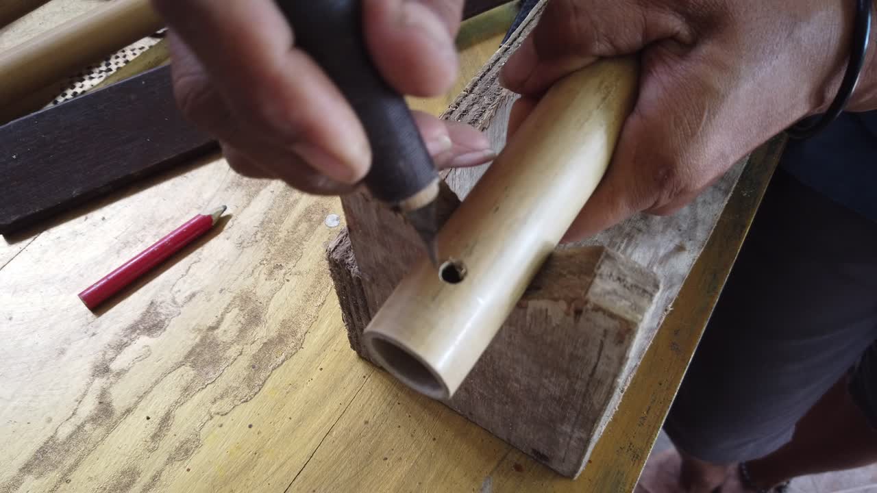 Hands of Flute Maker Artisan Works on Bamboo Musical Instrument, Bali Indonesia Traditional Handicrafts
