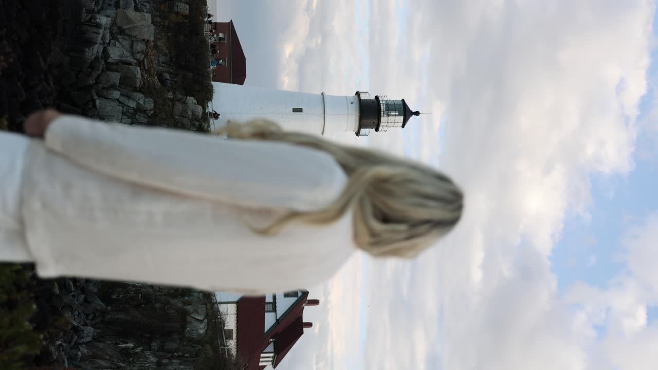 Donna bionda che guarda verso il faro di Portland Head Light