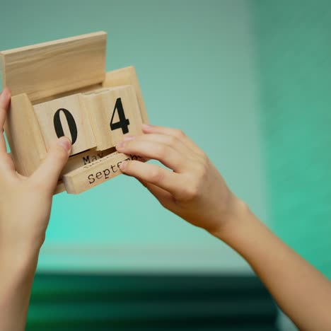 Boy changing wooden calendar block on 4th of July American Independence day