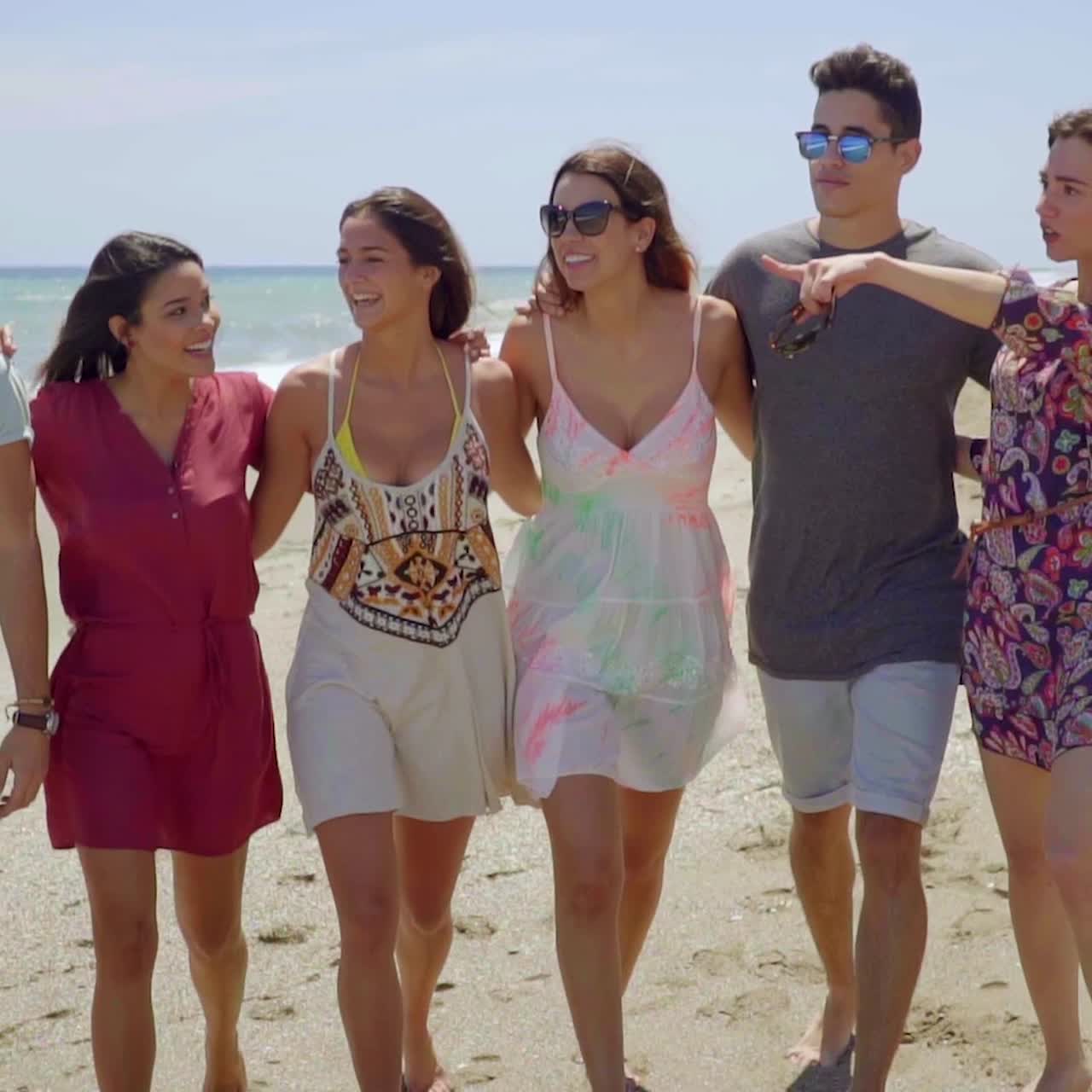 해변을 걷고 있는 어린 학생들의 행복한 그룹