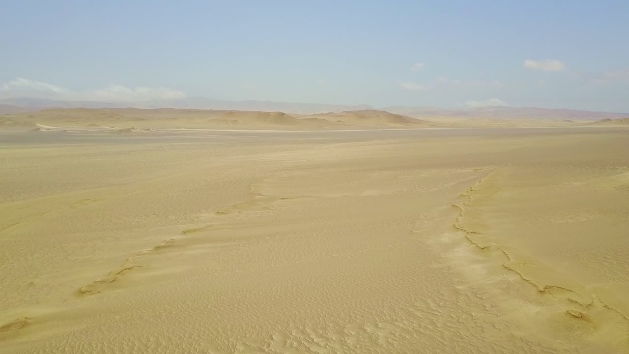 거대한 사막 풍경과 공중 드론이 모래 언덕 위로 올라와 아래로 기울어, 페루