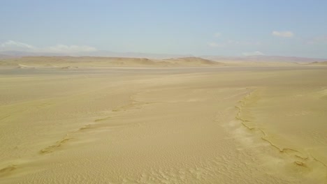 Vast-Desert-Landscape-with-Aerial-Drone-Rising-Over-the-Sand-Dunes-Tilting-Down,-Peru