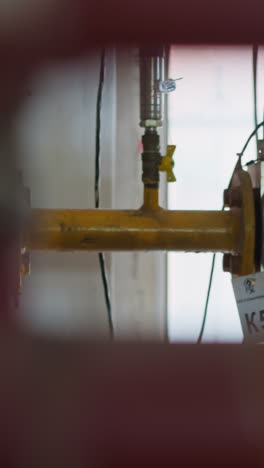 gas products distribution pipe with knots and pressure meter in mechanical house. pipeline system with safety blocks in industrial workshop
