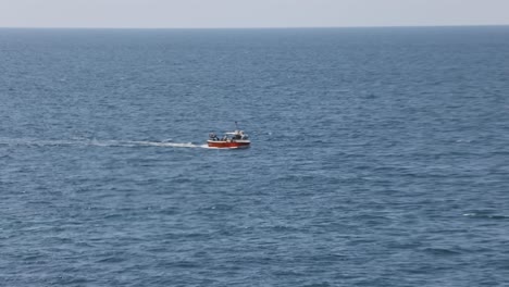 disparo de mano de un pequeño barco de pesca rojo que se dirige al puerto de newquay para descargar
