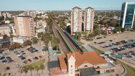 aerial view flying over train tracks revealing station at tigre city