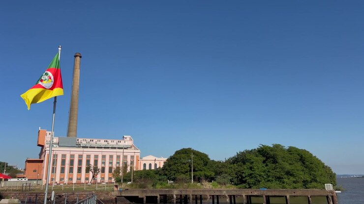 Bandiera dello stato del Rio Grande do Sul che sventola al vento davanti all'Usina do Gasômetro in una giornata di sole