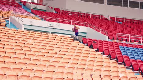 man running in empty stadium bleachers