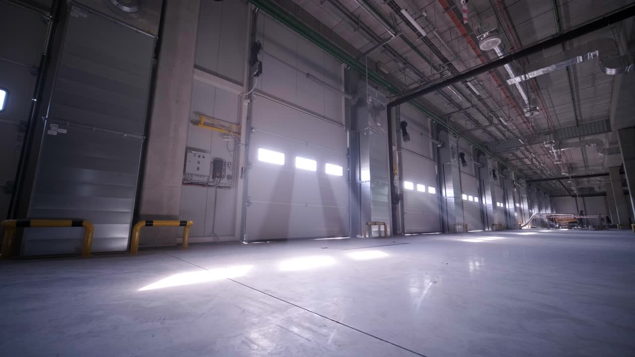 proceso de construcción de un gran almacén moderno con múltiples puertas de garaje para un fácil acceso y transporte de mercancías.