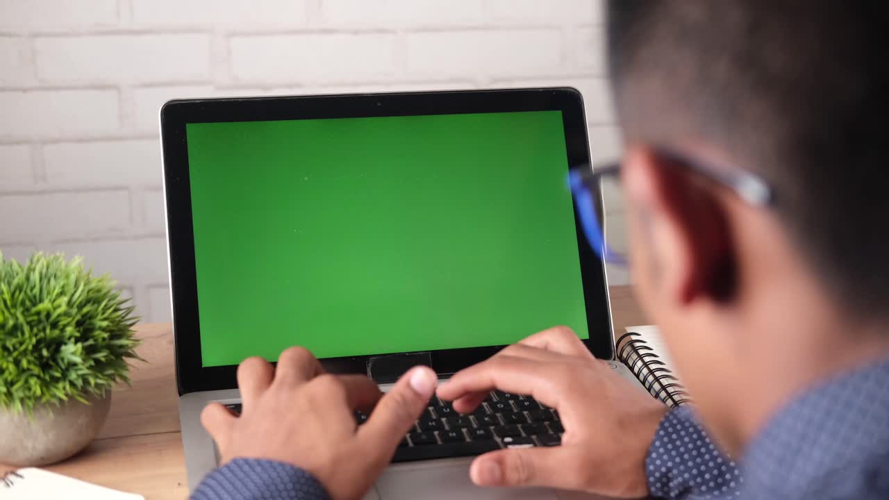 persona trabajando en una computadora portátil con una pantalla verde