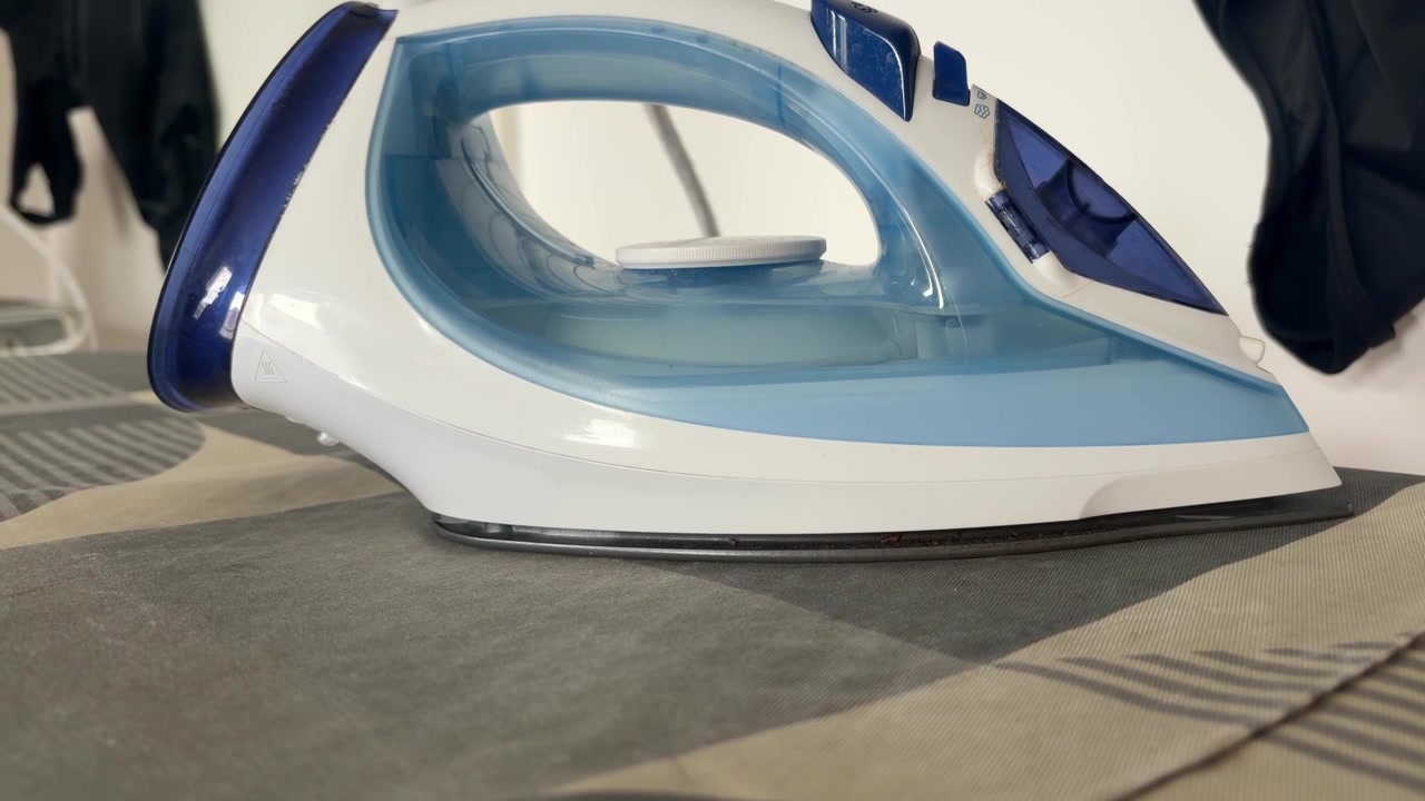 Electric Steam Iron Resting on Ironing Board Close Up
