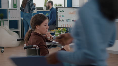 Busy-paralysed-handicapped-woman-worker-talking-at-phone-with-colleague