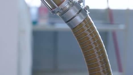 a tube carrying crushed olives through a small family run organic extra virgin olive oil production facility located in the region of abruzzo, italy that has been freshly harvested