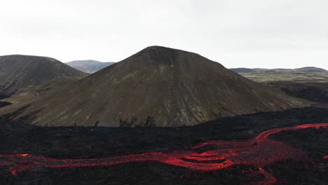 aerial landscape view over a lava stream coming from the volcanic eruptions at litli-hrutur, iceland, with smoke coming up