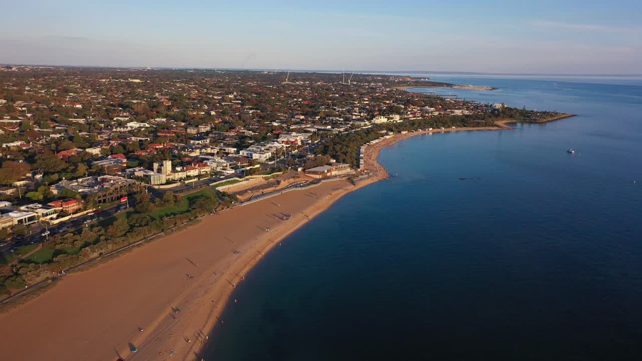 Drone footage flying towards Brighton's Colourful Bathing Boxes along the beach in autumn