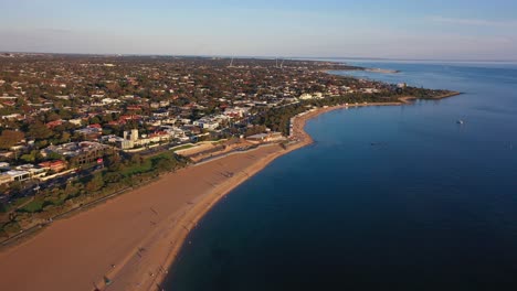 drone footage flying towards brighton's colourful bathing boxes along the beach in autumn