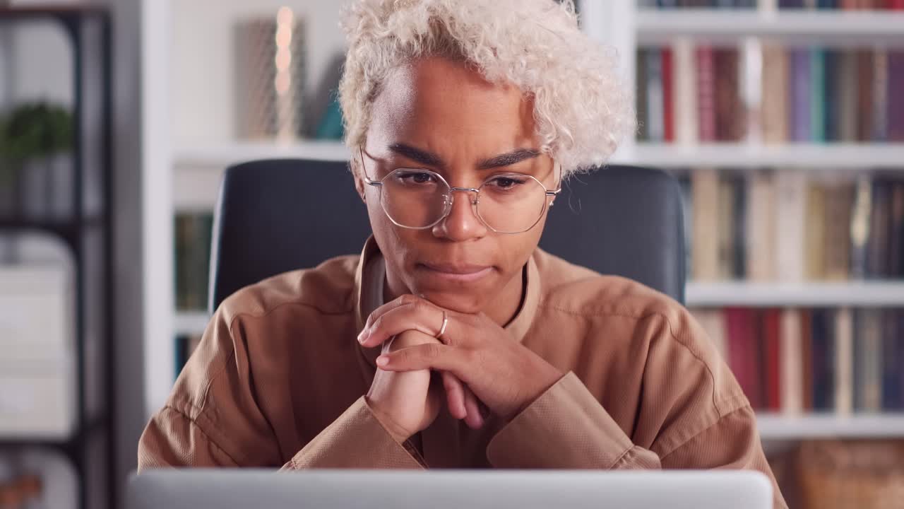 Young african american woman hesitant typing and looking at laptop