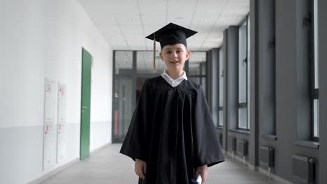 small boy throwing his mortarboard up in the air