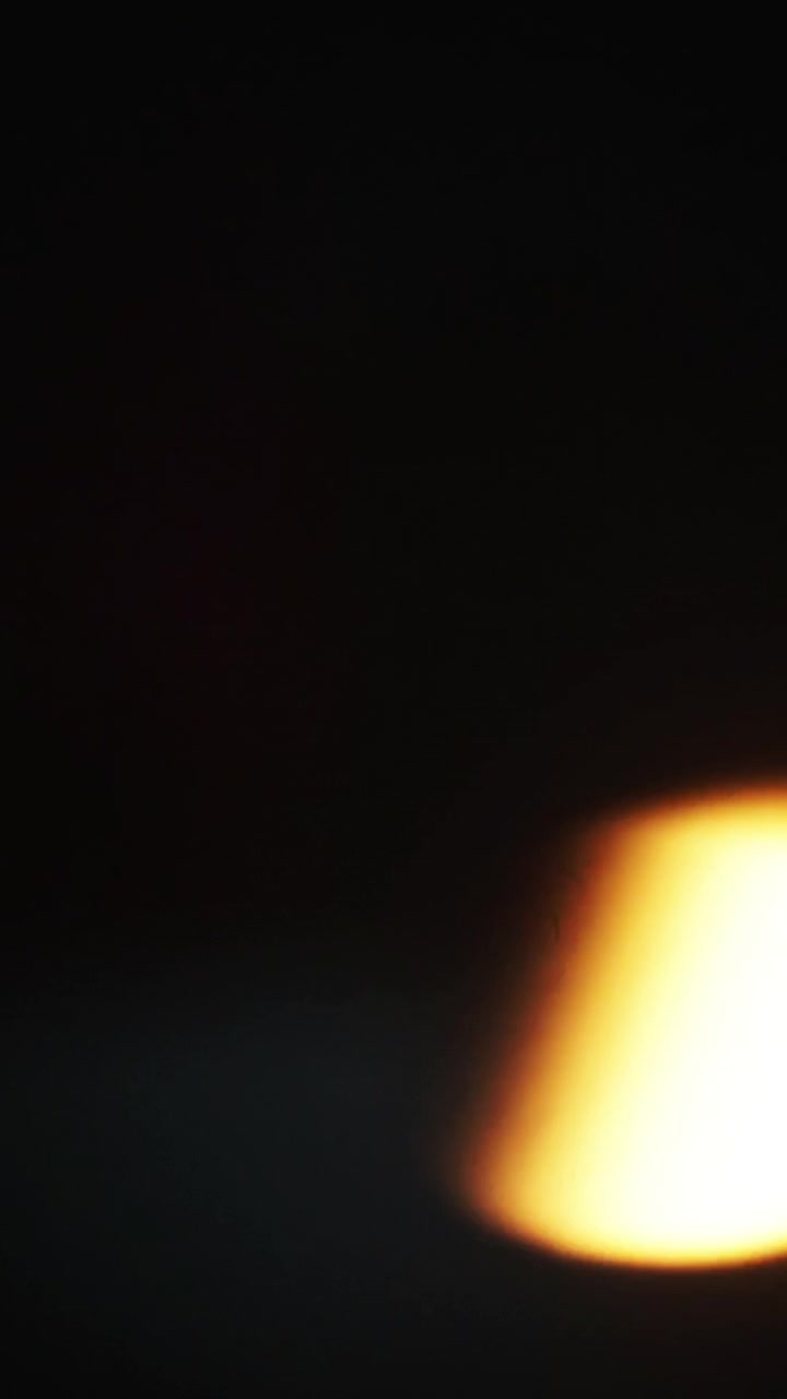Abstract bright light flare moving across a dark background