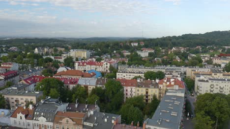 Tiro-De-Avance-De-Drones-Aéreos-Sobre-Edificios-Residenciales-En-Cracovia,-Cracovia-En-Polonia-A-Lo-Largo-De-Un-Terreno-Montañoso-En-El-Fondo