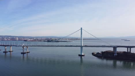 aerial drone shot slowly zooming out with the bay bridge in the background