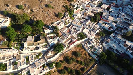 Pueblo-De-Lindos-En-Rodas,-Grecia-Con-La-Acrópolis-De-Lindos,-Casas-Y-El-Mar-Mediterráneo-Durante-El-Día-Filmado-Con-El-Dron