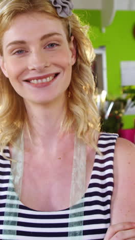 portrait of female florist standing with arms crossed in flower shop