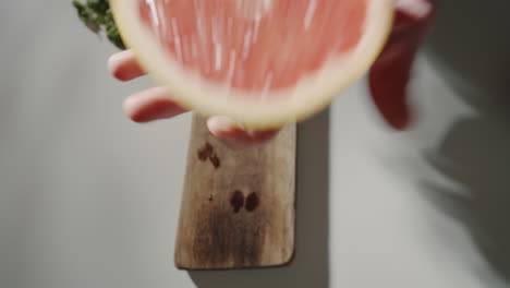 hand holding a grapefruit in the kitchen