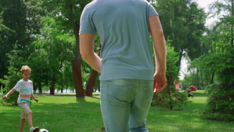 boy make football exercise with father closeup. family play soccer outdoors.