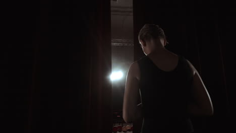 hermosa prima bailarina entrando en el escenario oscuro determinación inocencia silueta de humo cámara lenta