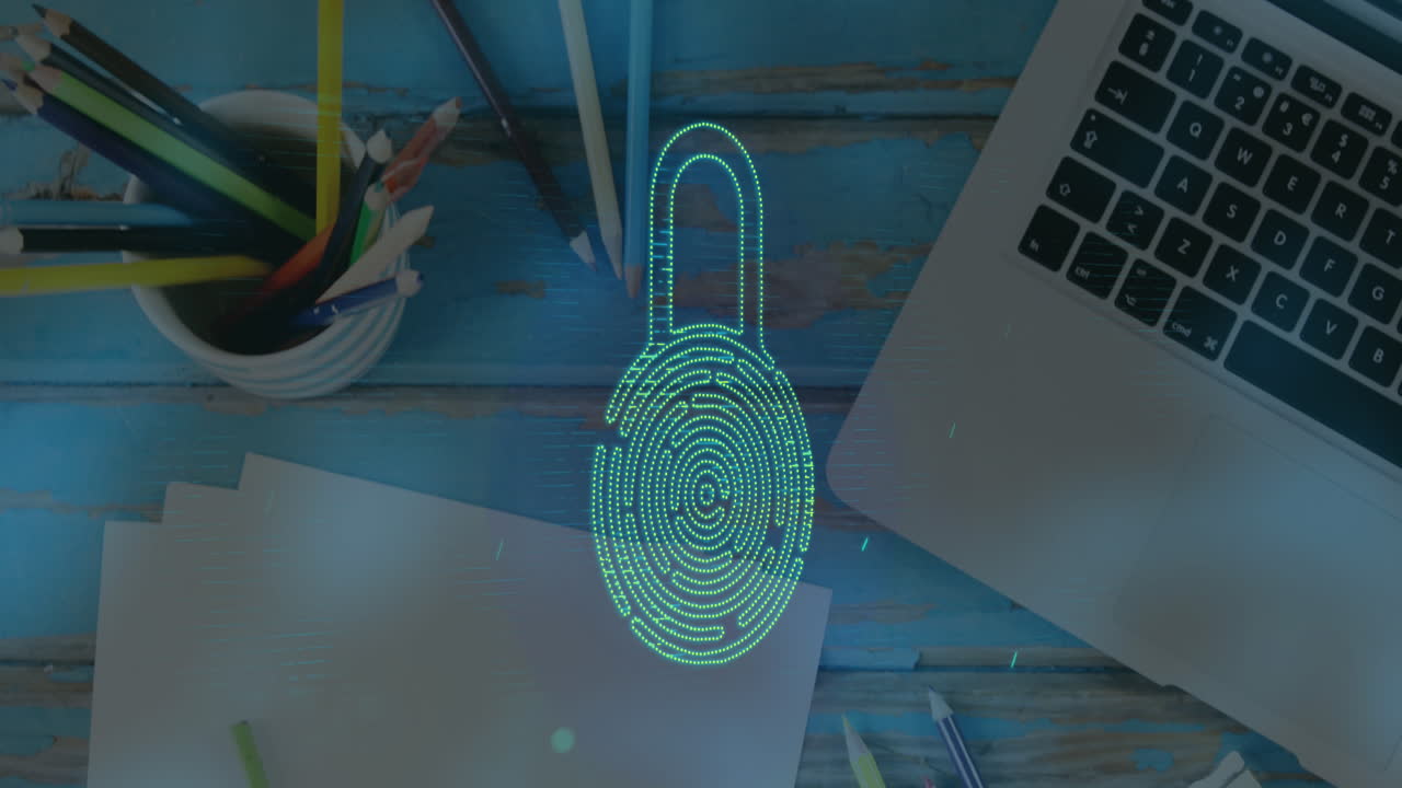 Animation of fingerprint in padlock, overhead view of pencil stands, laptop and papers on table