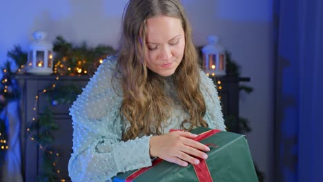 in slow motion, young woman preparing christmas gift with red ribbon