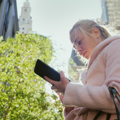 a business woman uses a tablet on a busy street in manhattan busy traffic