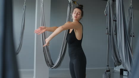 woman practicing aerial yoga in a studio