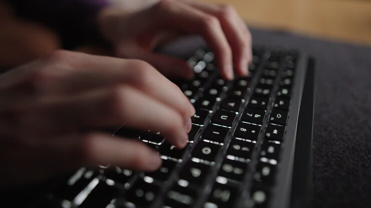 Wide moving closeup shot of fingers pushing down buttons on a keyboard