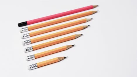 Close-up-of-pencils-arranged-on-white-background,-in-slow-motion