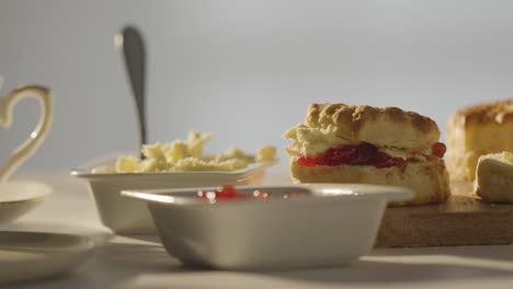 Nahaufnahme-Einer-Person-Mit-Traditionellem-Britischen-Nachmittagstee-Mit-Scones,-Sahne-Und-Marmelade-1