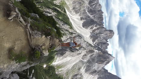 Aerial-drone-view-of-beautiful-blonde-girl-walking-on-the-edge-of-the-Cadini-Di-Misurina-Viewpoint,-Dolomites,-Italy,-Europe