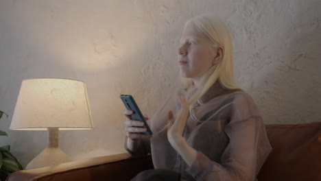mujer usando teléfono inteligente en el sofá